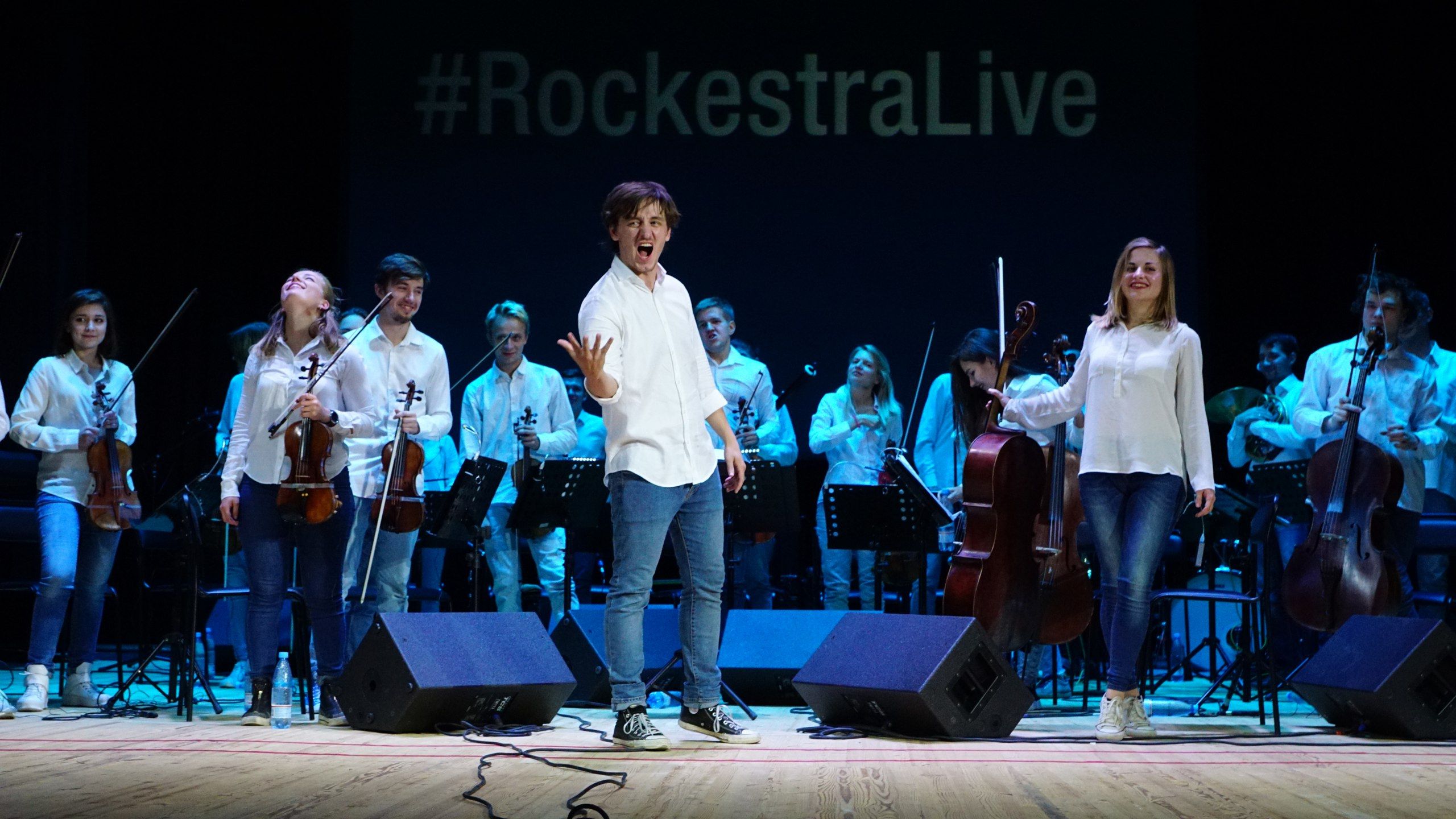 Sergey Akimov on stage with orchestra and RockestraLive screen