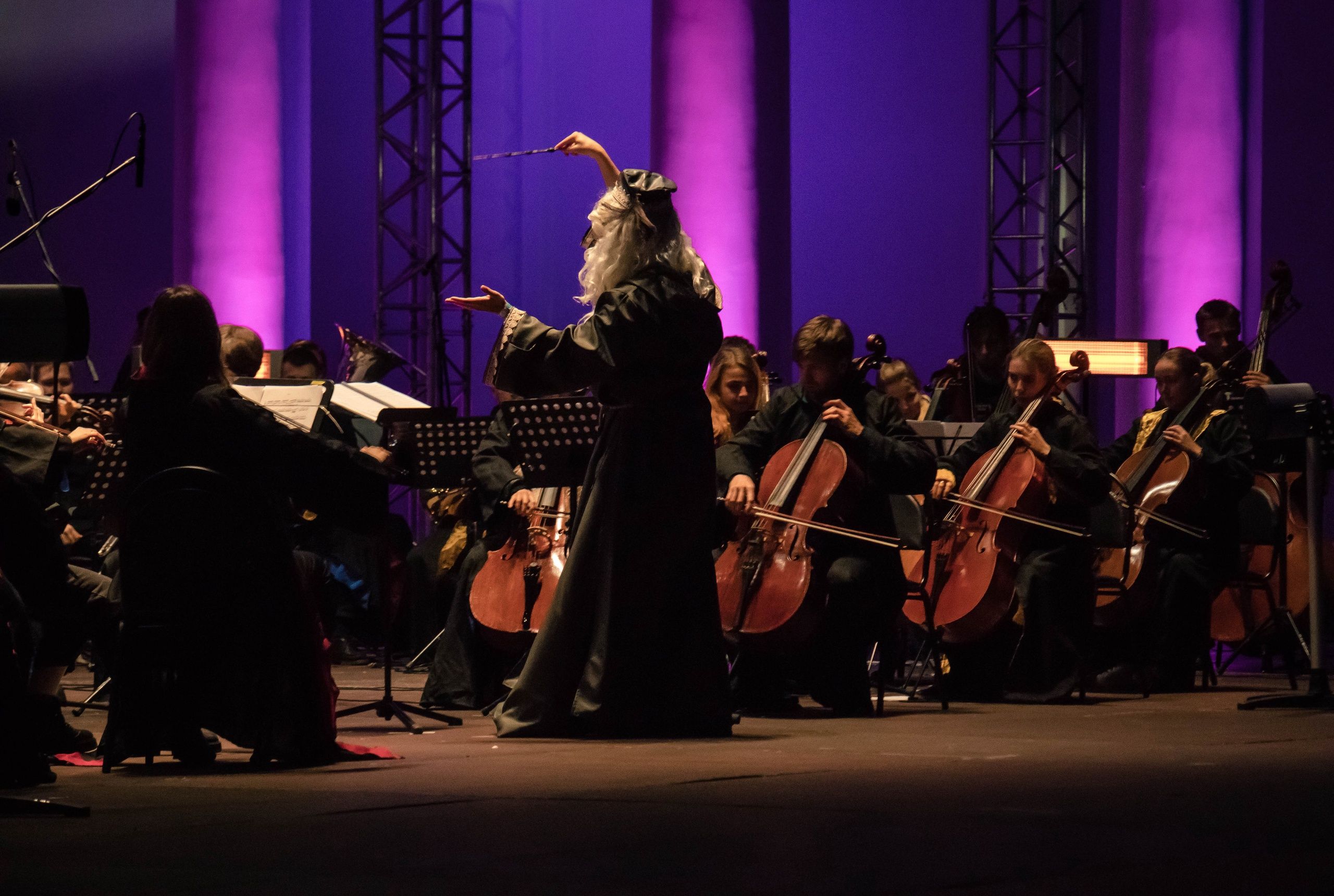 Sergey Akimov conducting in a dark formal orchestral setting